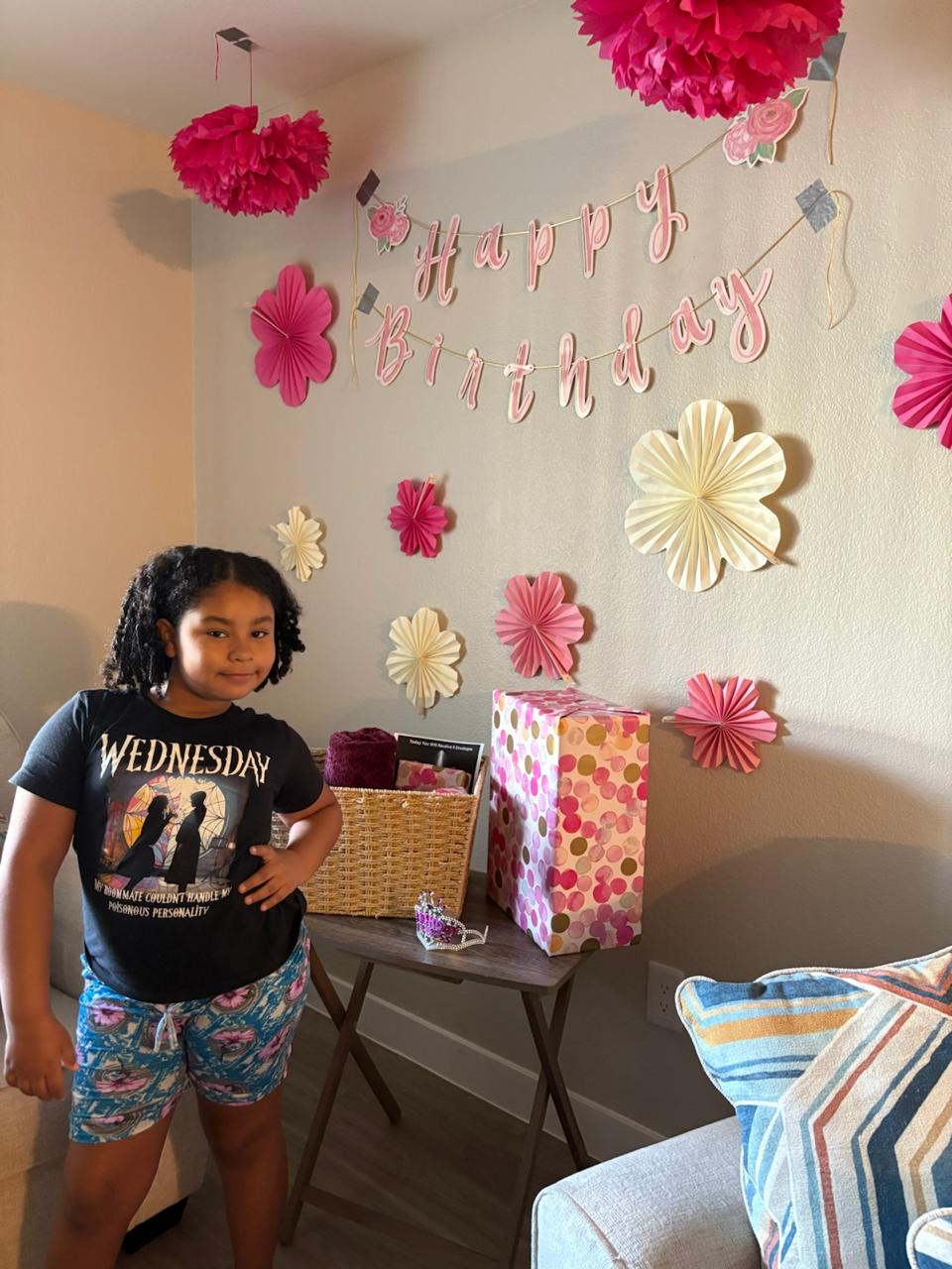 Isabella standing by birthday decorations